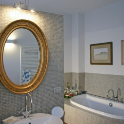 Casa B04 Foto del bagno padronale al piano primo. Rivestimento in mosaico.